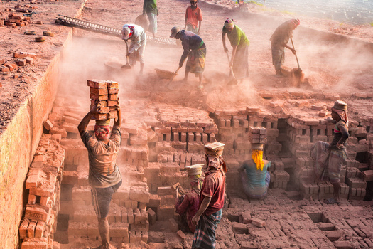 Kushtia District Khulna Division Bangladesh 28 November 2020 View of workers carrying bricks on their heads in a dusty brickyard. Kushtia District Khulna Division Bangladesh 28 November 2020 View of workers carrying bricks on their heads in a dusty brickyard.