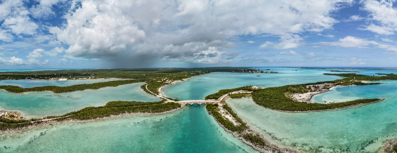 Aerial view of the bridge connecting Crab Cay with turquoise waters lush green vegetation and white sand beaches in Exuma Exuma The Bahamas. Aerial view of the bridge connecting Crab Cay with turquoise waters lush green vegetation and white sand beaches in Exuma Exuma The Bahamas.
