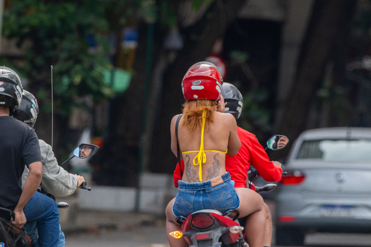 Rio de Janeiro Brazil 13 June 2026 View of a woman with a back tattoo riding on the back of a motorcycle through the streets of Copacabana.