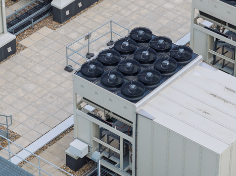 Aerial view of a data center rooftop featuring industrial cooling fans and HVAC units on a tiled surface in the United Kingdom.