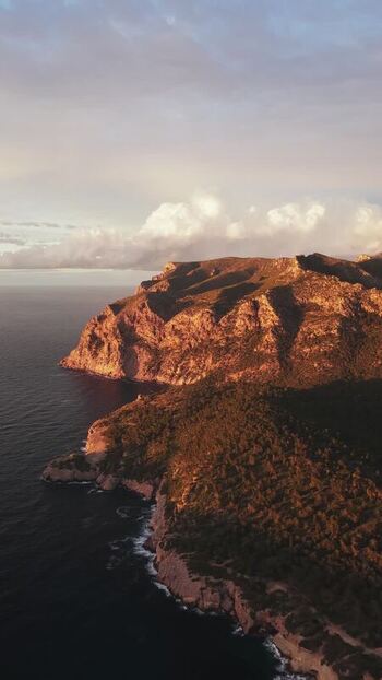 Aerial view of rugged coastal cliffs and sunset sea Spain.