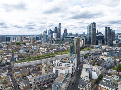 Aerial view of Shoreditch featuring modern skyscrapers dense urban rooftops and city streets in London England United Kingdom. Aerial view of Shoreditch featuring modern skyscrapers dense urban rooftops and city streets in London England United Kingdom.