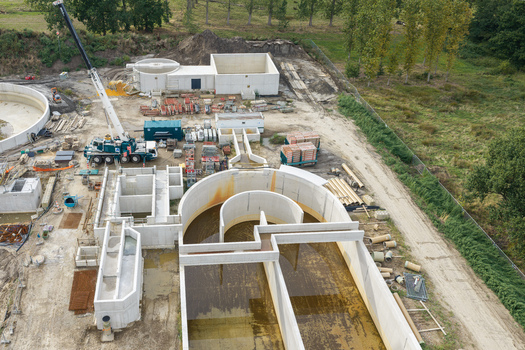 Diepenbeek Belgium 30 August 2026 Aerial view of a wastewater treatment plant under construction featuring concrete tanks a mobile crane and surrounding green fields. Diepenbeek Belgium 30 August 2026 Aerial view of a wastewater treatment plant under construction featuring concrete tanks a mobile crane and surrounding green fields.