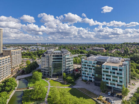 Aerial view of modern office buildings along Lakeside Drive surrounded by green spaces and a canal in London England United Kingdom. Aerial view of modern office buildings along Lakeside Drive surrounded by green spaces and a canal in London England United Kingdom.