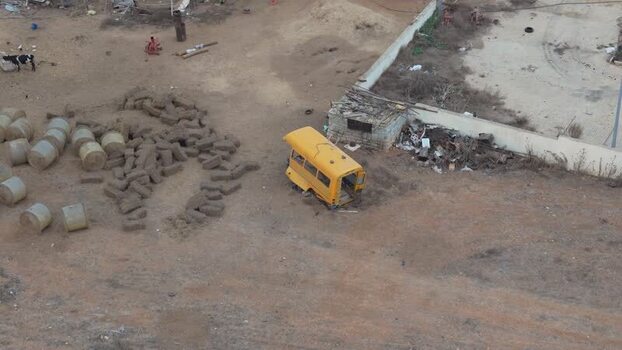 Aerial view of a yellow bus shell in a field Northern Cyprus.