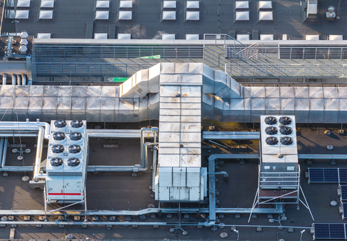Aerial view of a data center rooftop featuring large industrial HVAC cooling units metallic ventilation ductwork and solar panels in Gdansk Pomeranian Voivodeship Poland. Aerial view of a data center rooftop featuring large industrial HVAC cooling units metallic ventilation ductwork and solar panels in Gdansk Pomeranian Voivodeship Poland.