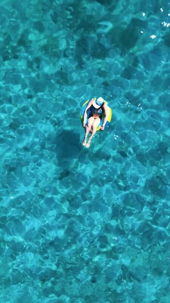 Aerial view of a woman floating in turquoise water Honduras. Aerial view of a woman floating in turquoise water Honduras.