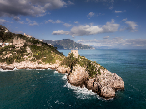 Aerial view of a rugged coastline meets the turquoise sea with ancient towers perched atop rocky cliffs Minori Italy. Aerial view of a rugged coastline meets the turquoise sea with ancient towers perched atop rocky cliffs Minori Italy.
