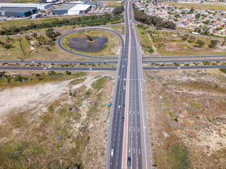 Aerial view of the Milnerton interchange featuring a multi lane highway and circular on ramp surrounded by suburban landscape in Cape Town Western Cape South Africa. Aerial view of the Milnerton interchange featuring a multi lane highway and circular on ramp surrounded by suburban landscape in Cape Town Western Cape South Africa.