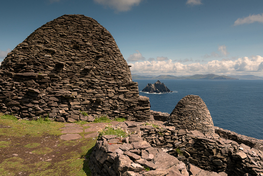 View of ancient stone beehive huts on the rugged cliffs of Great Skellig overlooking the Atlantic Ocean and Little Skellig in County Kerry Ireland. View of ancient stone beehive huts on the rugged cliffs of Great Skellig overlooking the Atlantic Ocean and Little Skellig in County Kerry Ireland.