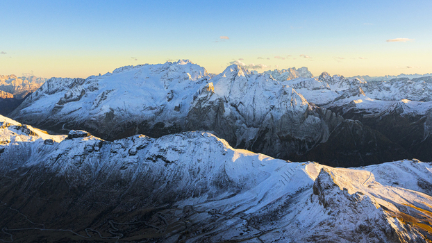 Aerial view of snow dusted peaks piercing the crisp air their jagged silhouettes a testament to nature s raw power Marmolada Dolomites Italy.