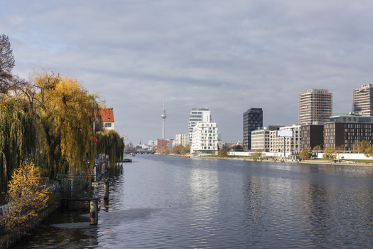 View of the Spree River with the Berlin TV Tower in the distance modern buildings and autumnal trees Berlin Berlin Germany. View of the Spree River with the Berlin TV Tower in the distance modern buildings and autumnal trees Berlin Berlin Germany.