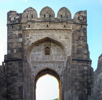 View of the historic stone gateway of Rohtas Fort with intricate architectural details and battlements against a clear blue sky in Dina Punjab Pakistan. View of the historic stone gateway of Rohtas Fort with intricate architectural details and battlements against a clear blue sky in Dina Punjab Pakistan.