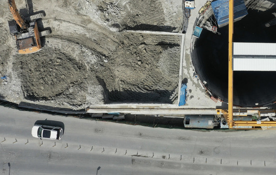 Aerial view of an active construction site featuring a large excavation pit heavy machinery and an excavator near a busy road in Avcilar Istanbul Turkiye. Aerial view of an active construction site featuring a large excavation pit heavy machinery and an excavator near a busy road in Avcilar Istanbul Turkiye.