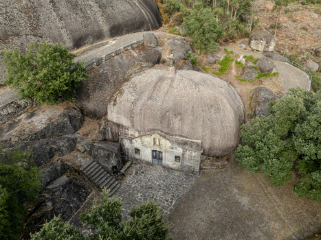 Aerial view of Santuario de Nossa Senhora da Lapa a unique chapel built under a giant granite boulder surrounded by stone paths and lush green trees in Soutelo Braga Portugal. Aerial view of Santuario de Nossa Senhora da Lapa a unique chapel built under a giant granite boulder surrounded by stone paths and lush green trees in Soutelo Braga Portugal.