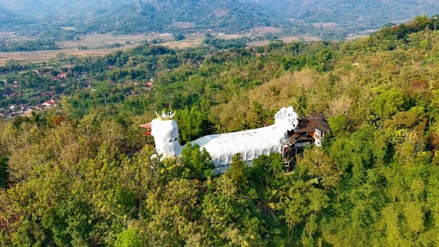 Aerial view of the unique Bukit Rhema Gereja Ayam a large bird shaped structure nestled amidst lush tropical forest and rolling hills in Kecamatan Borobudur Jawa Tengah Indonesia.