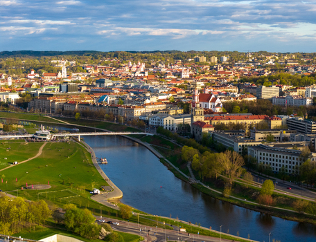 Aerial view of the Neris river winding through the historic city center with red roofed architecture and lush green parks Vilnius County Lithuania. Aerial view of the Neris river winding through the historic city center with red roofed architecture and lush green parks Vilnius County Lithuania.