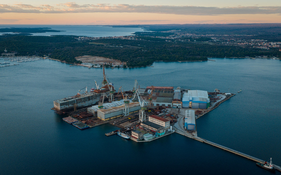 Aerial view of Uljanik Shipyard with industrial cranes dry docks and ships under construction situated on the coast of Pula Croatia. Aerial view of Uljanik Shipyard with industrial cranes dry docks and ships under construction situated on the coast of Pula Croatia.