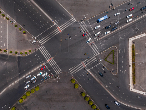 Aerial view of a busy road intersection with cars and motorcycles navigating through crosswalks on asphalt roads in Vietnam. Aerial view of a busy road intersection with cars and motorcycles navigating through crosswalks on asphalt roads in Vietnam.