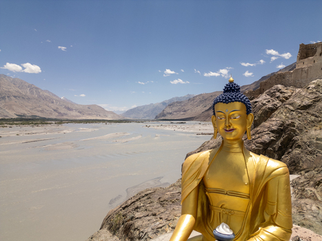 Aerial view of the golden Buddha statue at Charasa Gonpa overlooking the river valley and rugged mountains in Charasa Ladakh India.