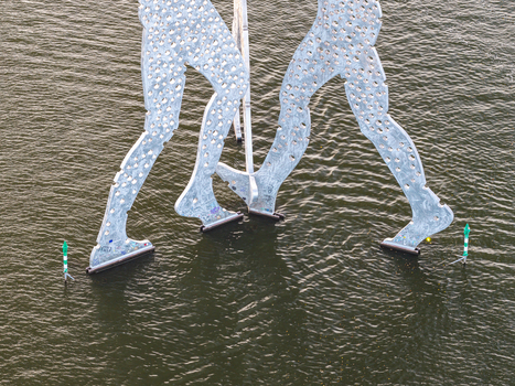Aerial view of the Molecule Men sculpture standing in the Spree river with its perforated aluminum figures reflecting on the water surface in Berlin Berlin Germany. Aerial view of the Molecule Men sculpture standing in the Spree river with its perforated aluminum figures reflecting on the water surface in Berlin Berlin Germany.