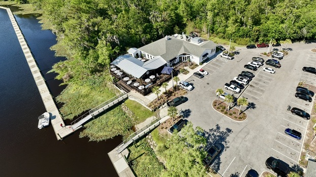 Aerial view of a restaurant with outdoor seating and a dock on the water a vivid contrast of dark water and lush greenery St. Augustine Florida United States. Aerial view of a restaurant with outdoor seating and a dock on the water a vivid contrast of dark water and lush greenery St. Augustine Florida United States.