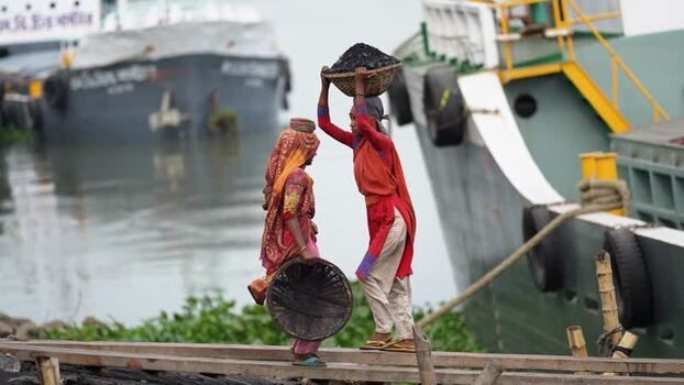 View of women carrying coal at Aminbazar port in Dhaka Bangladesh.