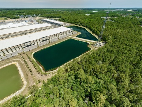 Aerial view of industrial warehouses and retention ponds near Saint Johns Parkway surrounded by lush green forests World Golf Village Florida United States. Aerial view of industrial warehouses and retention ponds near Saint Johns Parkway surrounded by lush green forests World Golf Village Florida United States.