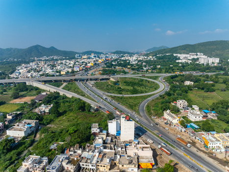 Aerial view of a highway interchange surrounded by urban buildings and green landscape in Udaipur Rajasthan India. Aerial view of a highway interchange surrounded by urban buildings and green landscape in Udaipur Rajasthan India.