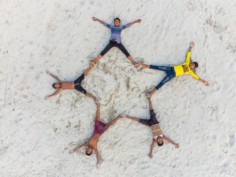 Alakjhari Bangladesh 26 July 2026 Aerial view of Jharbari ghat with five boys lying on the sand in a star formation.