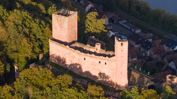 Aerial view of Henneburg castle ruins surrounded by lush green forests and the town of Stadtprozelten Bayern Germany.