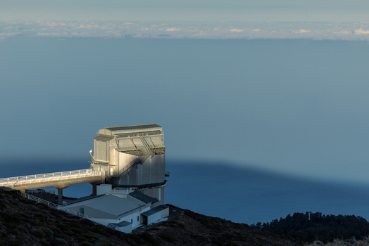 View of the modern Galileo National Telescope in the Roque de Los Muchachos Astrophysical Observatory walkway overlooking a sea of clouds Canarias Spain. View of the modern Galileo National Telescope in the Roque de Los Muchachos Astrophysical Observatory walkway overlooking a sea of clouds Canarias Spain.