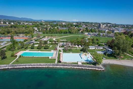 Aerial view of the public swimming pool complex and sports facilities along the shores of Lake Geneva with green lawns and athletic tracks in Morges Vaud Switzerland. Aerial view of the public swimming pool complex and sports facilities along the shores of Lake Geneva with green lawns and athletic tracks in Morges Vaud Switzerland.