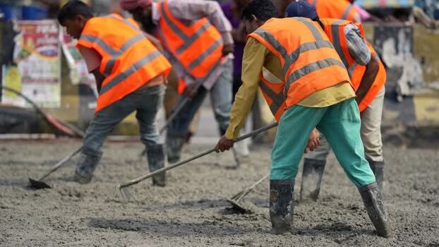 View of workers leveling concrete at a construction site Bangladesh. View of workers leveling concrete at a construction site Bangladesh.