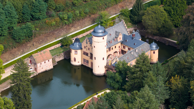 Aerial view of Schloss Mespelbrunn a historic water castle surrounded by a moat and dense forest in Mespelbrunn Bayern Germany. Aerial view of Schloss Mespelbrunn a historic water castle surrounded by a moat and dense forest in Mespelbrunn Bayern Germany.