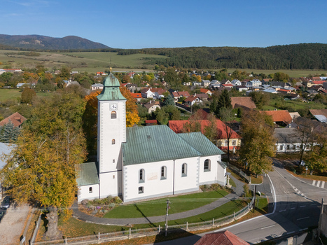 Aerial view of a white church with a green roof nestled among vibrant autumn trees and village homes overlooking distant hills Klastor pod Znievom Zilina Region Slovakia. Aerial view of a white church with a green roof nestled among vibrant autumn trees and village homes overlooking distant hills Klastor pod Znievom Zilina Region Slovakia.