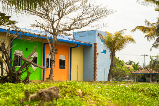 View of a colorful modern building with green orange and blue facades surrounded by palm trees and lush vegetation in Sri Lanka. View of a colorful modern building with green orange and blue facades surrounded by palm trees and lush vegetation in Sri Lanka.