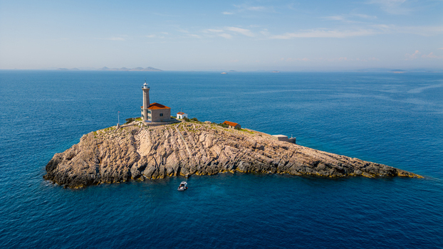 Aerial view of Blitvenica Lighthouse on a rugged rocky islet surrounded by the deep blue Adriatic Sea Zirje Sibensko kninska zupa Croatia. Aerial view of Blitvenica Lighthouse on a rugged rocky islet surrounded by the deep blue Adriatic Sea Zirje Sibensko kninska zupa Croatia.