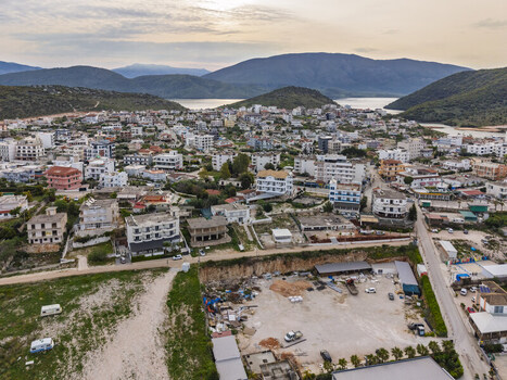 Aerial view of the coastal town of Ksamil featuring dense residential buildings surrounding hills and the sea in the background during golden hour in Ksamil Vlore County Albania. Aerial view of the coastal town of Ksamil featuring dense residential buildings surrounding hills and the sea in the background during golden hour in Ksamil Vlore County Albania.