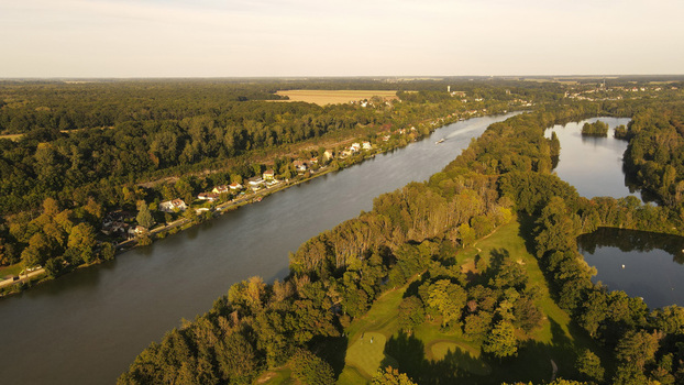Aerial view of the Seine river flowing past dense forests and calm ponds in the rural landscape of Chartrettes Ile de France France. Aerial view of the Seine river flowing past dense forests and calm ponds in the rural landscape of Chartrettes Ile de France France.