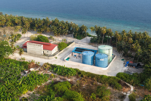 Aerial view of a lush tropical island with dense palm forests white sandy beaches and a vibrant coral reef in Vaikaradhoo Haa Dhaalu Atoll Maldives. Aerial view of a lush tropical island with dense palm forests white sandy beaches and a vibrant coral reef in Vaikaradhoo Haa Dhaalu Atoll Maldives.