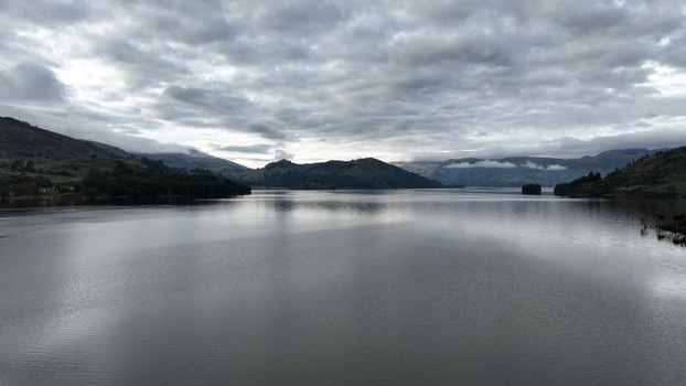 Aerial view of Corani Lake surrounded by rolling hills and lush vegetation under a cloudy sky in Chapare Cochabamba Department Bolivia. Aerial view of Corani Lake surrounded by rolling hills and lush vegetation under a cloudy sky in Chapare Cochabamba Department Bolivia.