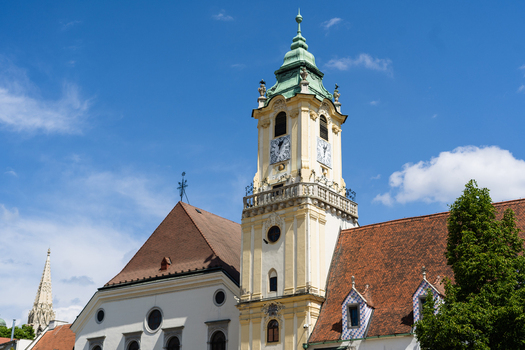 View of the Old Town Hall clock tower with its green baroque roof and historic white facade under a clear blue sky in Bratislava Bratislava Region Slovakia. View of the Old Town Hall clock tower with its green baroque roof and historic white facade under a clear blue sky in Bratislava Bratislava Region Slovakia.