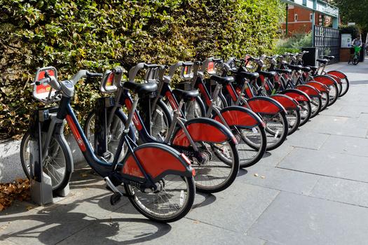 View of a row of red and blue Cycles parked at a docking station on a sidewalk in London England United Kingdom.