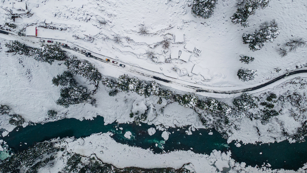 Aerial view of a serpentine road cuts through a snow laden landscape where the turquoise river contrasts with the stark white Sharda Azad Kashmir Pakistan. Aerial view of a serpentine road cuts through a snow laden landscape where the turquoise river contrasts with the stark white Sharda Azad Kashmir Pakistan.