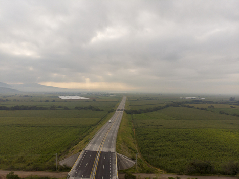 Aerial view of the Autopista Mexico Guadalajara highway stretching through vast agricultural fields under a cloudy sky in Ecuandureo Michoacan Mexico. Aerial view of the Autopista Mexico Guadalajara highway stretching through vast agricultural fields under a cloudy sky in Ecuandureo Michoacan Mexico.