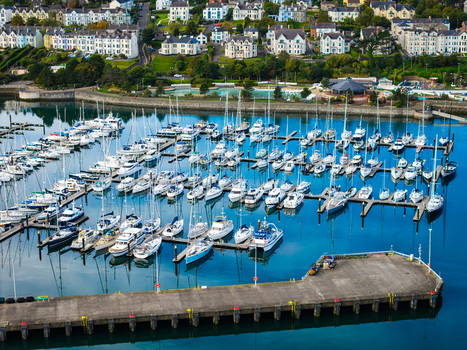 Aerial view of Bangor Harbour and Town with sailboats and yachts moored in the marina surrounded by coastal buildings and lush green hills in Bangor Northern Ireland United Kingdom.