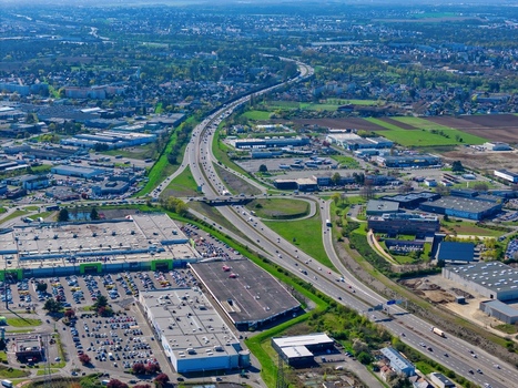 Aerial view of a sprawling network of roads cutting through the landscape connecting buildings and green spaces under a vast sky Sausheim Grand Est France.
