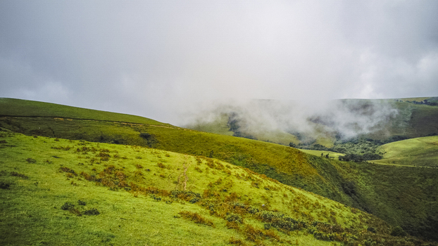 Aerial view of serene verdant rolling hills partially shrouded in ethereal mist Obudu Cross River Nigeria.