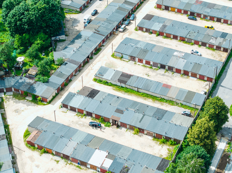 Aerial view of rows of garages in the Zemgale Suburb with paved access paths and parked cars in Riga Latvia.